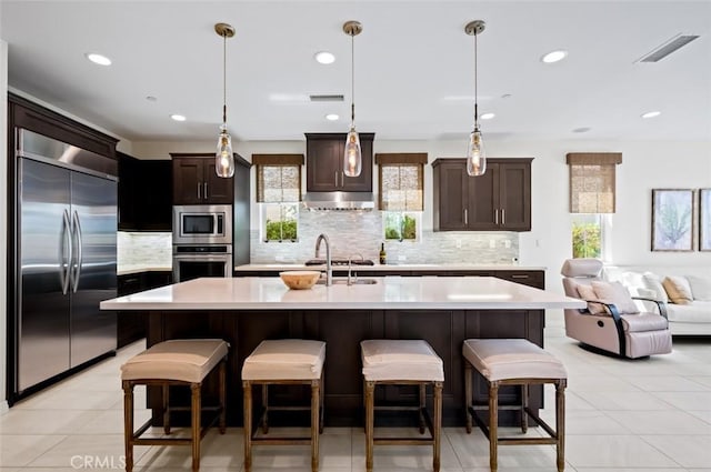 126 Brambles, Irvine, CA 92618 - kitchen with built in appliances, light countertops, tasteful backsplash, dark brown cabinetry, and recessed lighting
