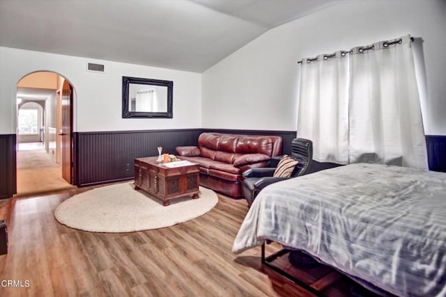 5500 Casitas Pass Rd, Ventura, CA 93001 - bedroom with vaulted ceiling, arched walkways, a wainscoted wall, and wood finished floors