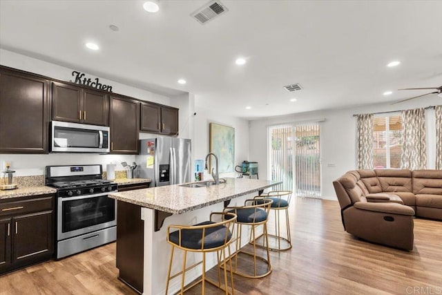 861 Colton Ave, Colton, CA 92324 - kitchen with stainless steel appliances, a sink, open floor plan, a kitchen bar, and recessed lighting