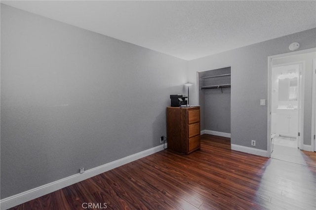 5805 Vista Del Cerro, Oroville, CA 95966 - unfurnished bedroom featuring dark wood finished floors, baseboards, a closet, an office area, and a textured ceiling