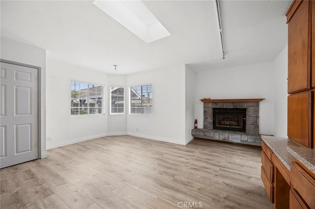 10441 La Mirada Blvd, Whittier, CA 90604 - unfurnished living room with a skylight, light wood-type flooring, a fireplace, baseboards, and rail lighting
