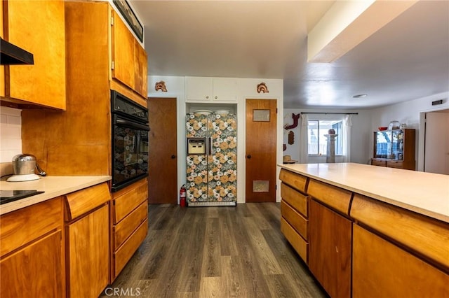3080 State Highway 45, Glenn, CA 95943 - kitchen featuring oven, light countertops, dark wood-style flooring, brown cabinets, and range hood