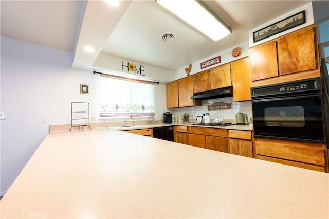 3080 State Highway 45, Glenn, CA 95943 - kitchen featuring black appliances, under cabinet range hood, light countertops, decorative backsplash, and brown cabinets
