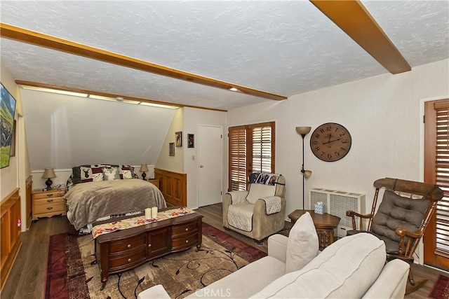 1249 Yellowstone Dr, Lake Arrowhead, CA 92352 - bedroom featuring wood finished floors, beamed ceiling, wainscoting, heating unit, and a textured ceiling