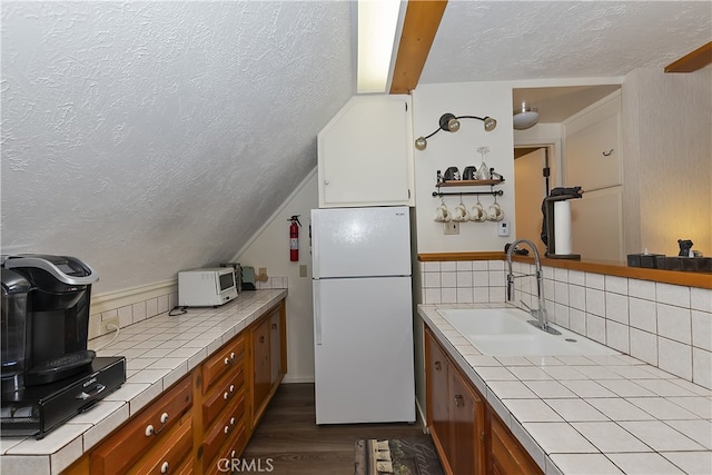 1249 Yellowstone Dr, Lake Arrowhead, CA 92352 - kitchen with freestanding refrigerator, tile countertops, a textured ceiling, a sink, and dark wood-style flooring
