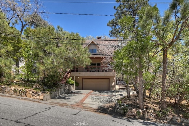 1249 Yellowstone Dr, Lake Arrowhead, CA 92352 - view of property hidden behind natural elements with driveway, a garage, and a chimney