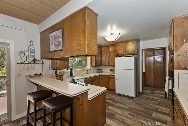 1249 Yellowstone Dr, Lake Arrowhead, CA 92352 - kitchen with freestanding refrigerator, a peninsula, brown cabinetry, and healthy amount of natural light