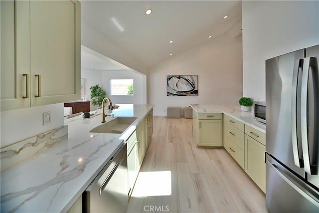 21651 Hilaria, Huntington Beach, CA 92646 - kitchen with stainless steel appliances, a sink, vaulted ceiling, light wood finished floors, and a peninsula