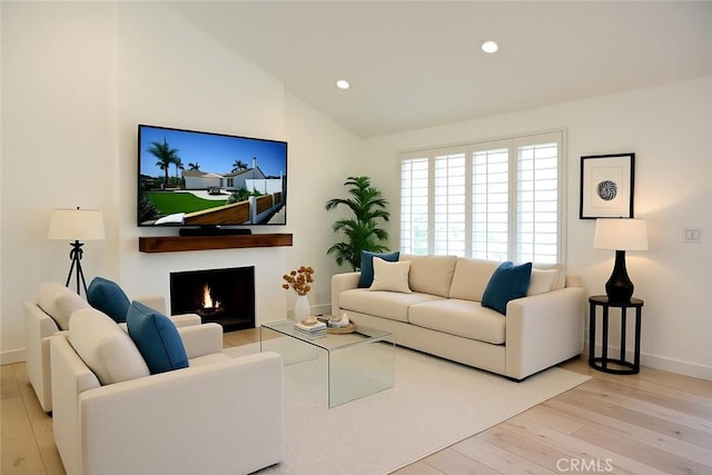 21651 Hilaria, Huntington Beach, CA 92646 - living area featuring wood finished floors, vaulted ceiling, baseboards, recessed lighting, and a warm lit fireplace