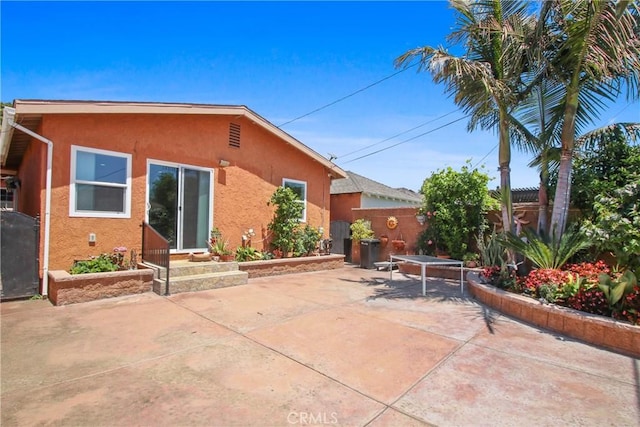 3950 E De Ora Way, Long Beach, CA 90815 - rear view of house with stucco siding, a patio area, fence, and entry steps