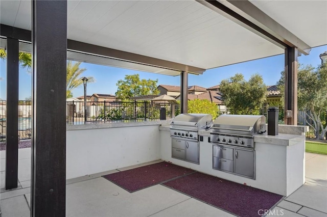 80218 Whisper Rock Way, La Quinta, CA 92253 - view of patio with grilling area, an outdoor kitchen, fence, and a residential view
