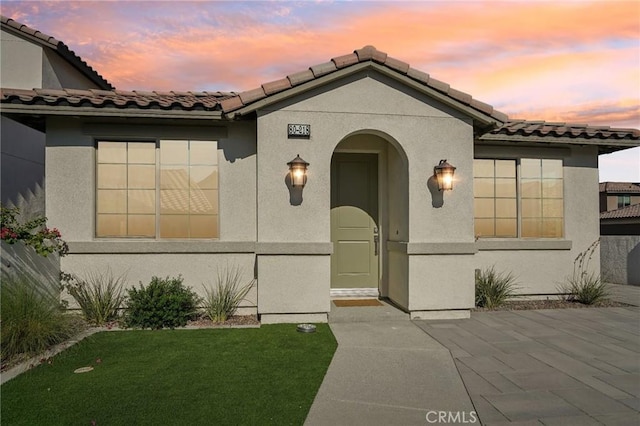 80218 Whisper Rock Way, La Quinta, CA 92253 - view of front facade with a tile roof, stucco siding, a patio area, and a front lawn