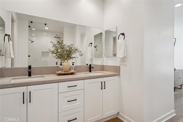 80218 Whisper Rock Way, La Quinta, CA 92253 - full bathroom featuring tiled shower, double vanity, wood finished floors, and baseboards
