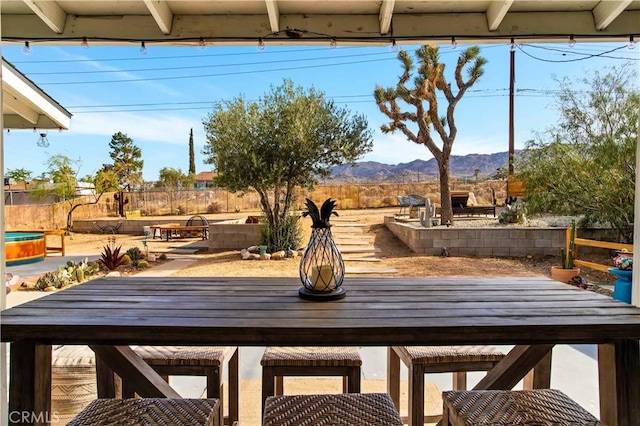 61475 Alta Vista Dr, Joshua Tree, CA 92252 - view of patio with outdoor dining space, a mountain view, and a fenced backyard