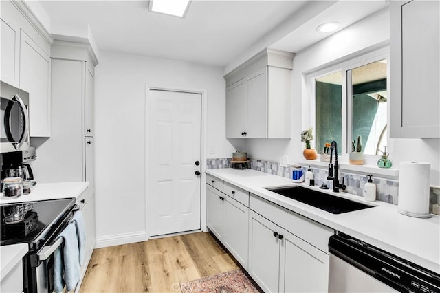 61475 Alta Vista Dr, Joshua Tree, CA 92252 - kitchen with dishwashing machine, a sink, stainless steel microwave, light wood finished floors, and electric range oven