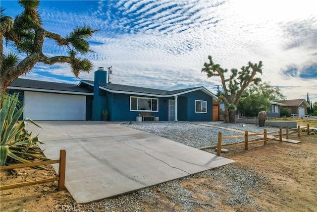 61475 Alta Vista Dr, Joshua Tree, CA 92252 - ranch-style house featuring an attached garage, concrete driveway, fence, and a chimney