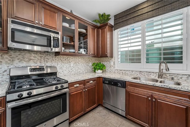 3105 E Discovery St, Ontario, CA 91762 - kitchen featuring appliances with stainless steel finishes, a sink, tasteful backsplash, light stone countertops, and glass insert cabinets