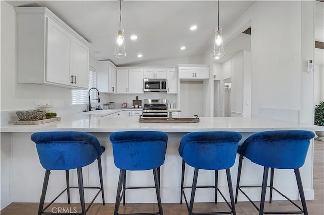 6294 Sunnyslope Rd, Phelan, CA 92371 - kitchen featuring stainless steel appliances, a sink, a peninsula, white cabinetry, and lofted ceiling