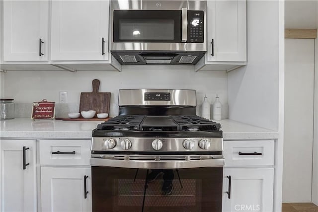 6294 Sunnyslope Rd, Phelan, CA 92371 - kitchen with stainless steel appliances, white cabinetry, and light stone countertops