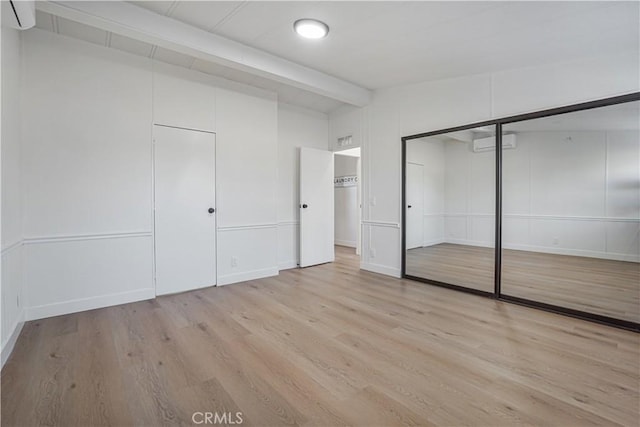 6294 Sunnyslope Rd, Phelan, CA 92371 - unfurnished bedroom with a wall mounted AC, light wood-type flooring, a closet, and baseboards