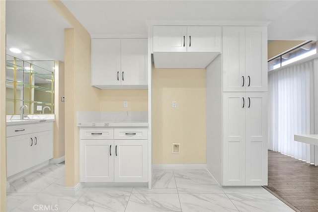 23020 Paseo De Terrado Unit 2, Diamond Bar, CA 91765 - kitchen with light marble finish floors, white cabinetry, baseboards, and a sink