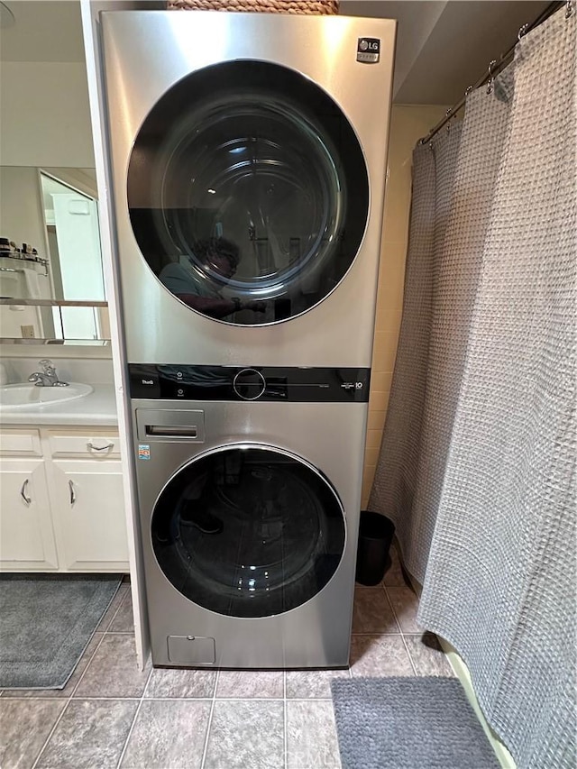 253 Calle Aragon Unit F, Laguna Woods, CA 92637 - laundry room featuring stacked washer / drying machine, a sink, and tile patterned flooring