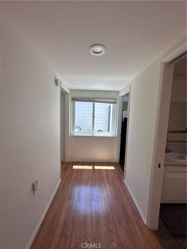 253 Calle Aragon Unit F, Laguna Woods, CA 92637 - corridor featuring a sink, wood finished floors, and baseboards