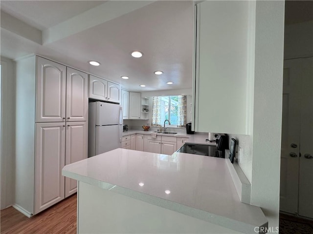 253 Calle Aragon Unit F, Laguna Woods, CA 92637 - kitchen featuring freestanding refrigerator, a sink, recessed lighting, light wood finished floors, and white cabinetry
