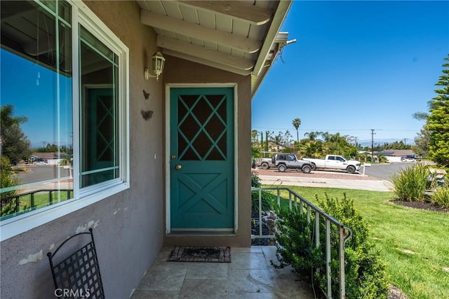 281 Harruby Dr, Calimesa, CA 92320 - view of exterior entry with stucco siding and a lawn