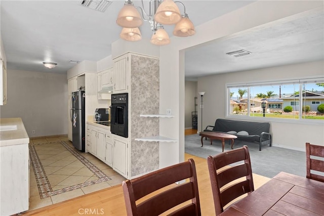 281 Harruby Dr, Calimesa, CA 92320 - kitchen with freestanding refrigerator, a chandelier, under cabinet range hood, black oven, and white cabinets