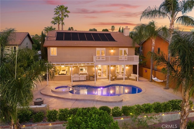 40493 Calle Katerine, Temecula, CA 92591 - back of house at dusk with outdoor lounge area, a balcony, solar panels, a tile roof, and a patio