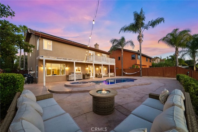 40493 Calle Katerine, Temecula, CA 92591 - pool at dusk with an outdoor living space with a fire pit, a patio, a fenced backyard, and an in-ground hot tub