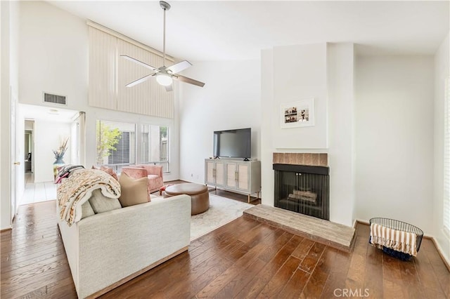 38970 Paseo De Oro, Murrieta, CA 92563 - living room featuring hardwood / wood-style flooring, ceiling fan, a fireplace with raised hearth, and high vaulted ceiling