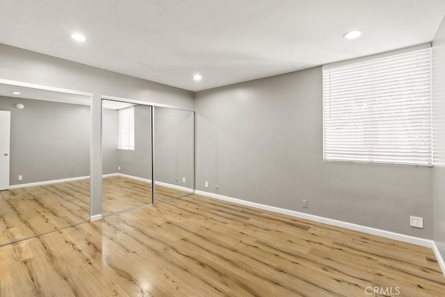 18620 Hatteras St Unit 223, Tarzana, CA 91356 - unfurnished bedroom featuring baseboards, multiple closets, wood finished floors, multiple windows, and recessed lighting