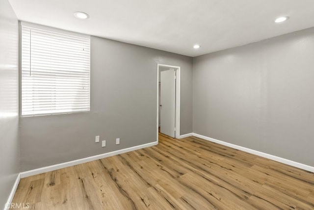empty room featuring baseboards, wood finished floors, and recessed lighting