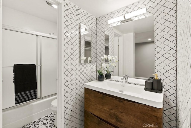 full bathroom featuring toilet, combined bath / shower with glass door, vanity, and tile patterned floors