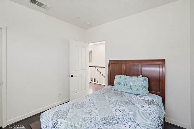 bedroom with baseboards and wood finished floors