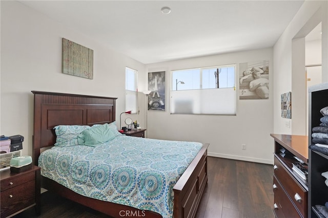 bedroom featuring dark wood finished floors and baseboards