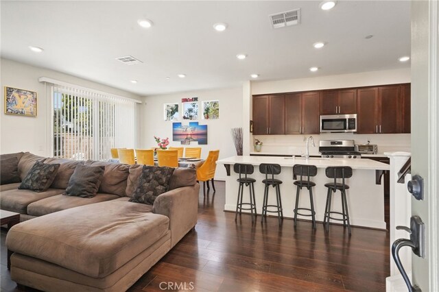 living area with recessed lighting and dark wood-style flooring