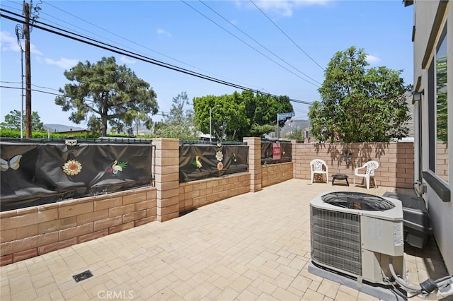 view of patio / terrace with central AC, an outdoor fire pit, and a fenced backyard