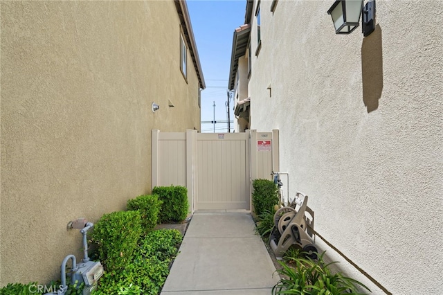 view of home's exterior with stucco siding and fence