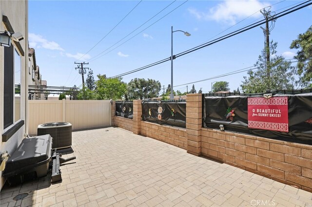 view of patio / terrace with central AC and fence