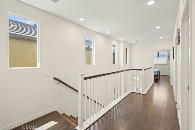 hallway featuring an upstairs landing, wood finished floors, healthy amount of natural light, recessed lighting, and baseboards