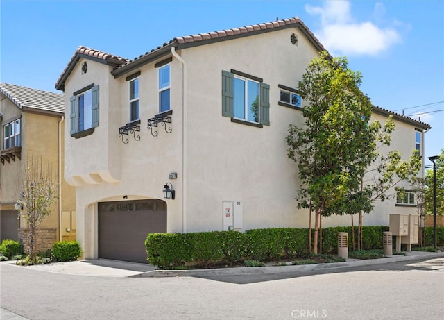 view of front of house featuring stucco siding, a garage, and a tiled roof