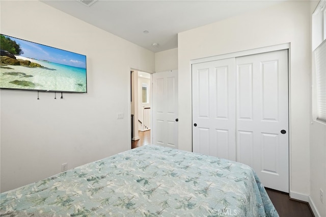 bedroom with dark wood-style flooring and a closet