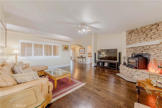 4428 Trumbo Ct, Phelan, CA 92371 - living room featuring arched walkways, a ceiling fan, a wood stove, wood finished floors, and baseboards
