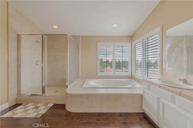 4428 Trumbo Ct, Phelan, CA 92371 - bathroom with lofted ceiling, a shower stall, a bath, wood finished floors, and vanity