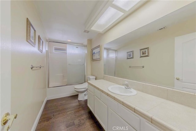 4428 Trumbo Ct, Phelan, CA 92371 - full bathroom with wood finished floors, toilet, vanity, enclosed tub / shower combo, and baseboards