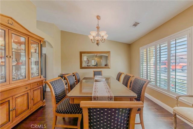 4428 Trumbo Ct, Phelan, CA 92371 - dining space with dark wood-style floors, a chandelier, baseboards, arched walkways, and lofted ceiling