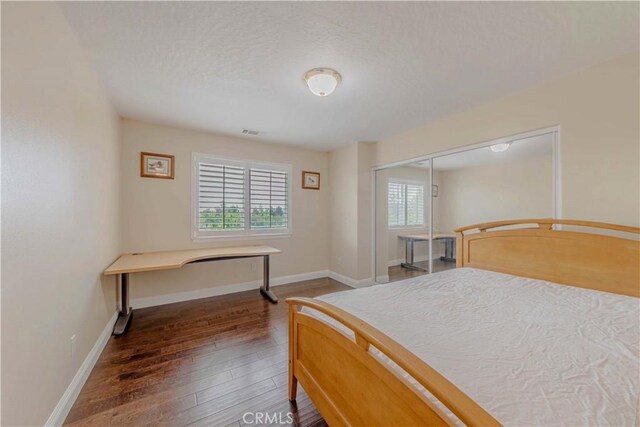4428 Trumbo Ct, Phelan, CA 92371 - bedroom with wood-type flooring, baseboards, a textured ceiling, and a closet